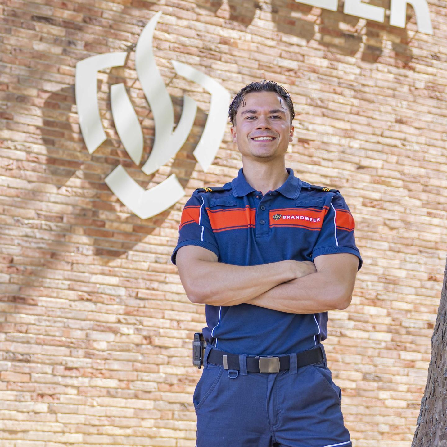 Lucas met zijn brandweerpak aan voor de brandweerkazerne