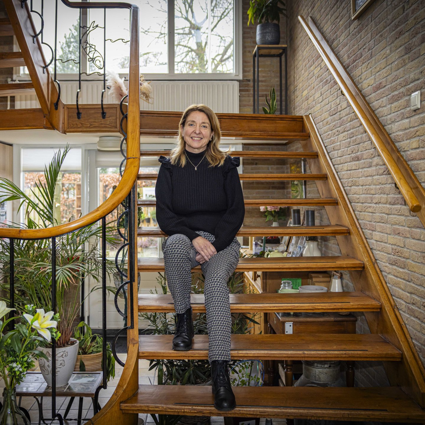 Sandra zittend op haar trap in haar woning