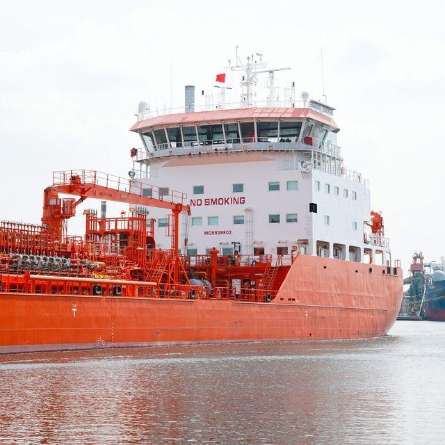 Groot wit, rood, blauw gekleurd zeeschip, bekeken vanaf het water