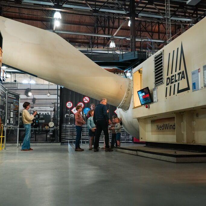 Bezoekers Industrieel Museum staan bij de kop en een gigantisch grote wiek van een windmolen