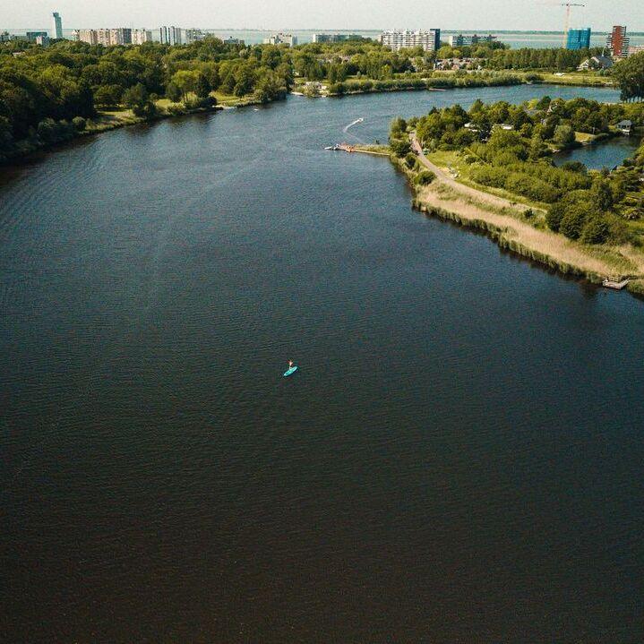 kano op een grote kreek met de skyline van Terneuzen erachter