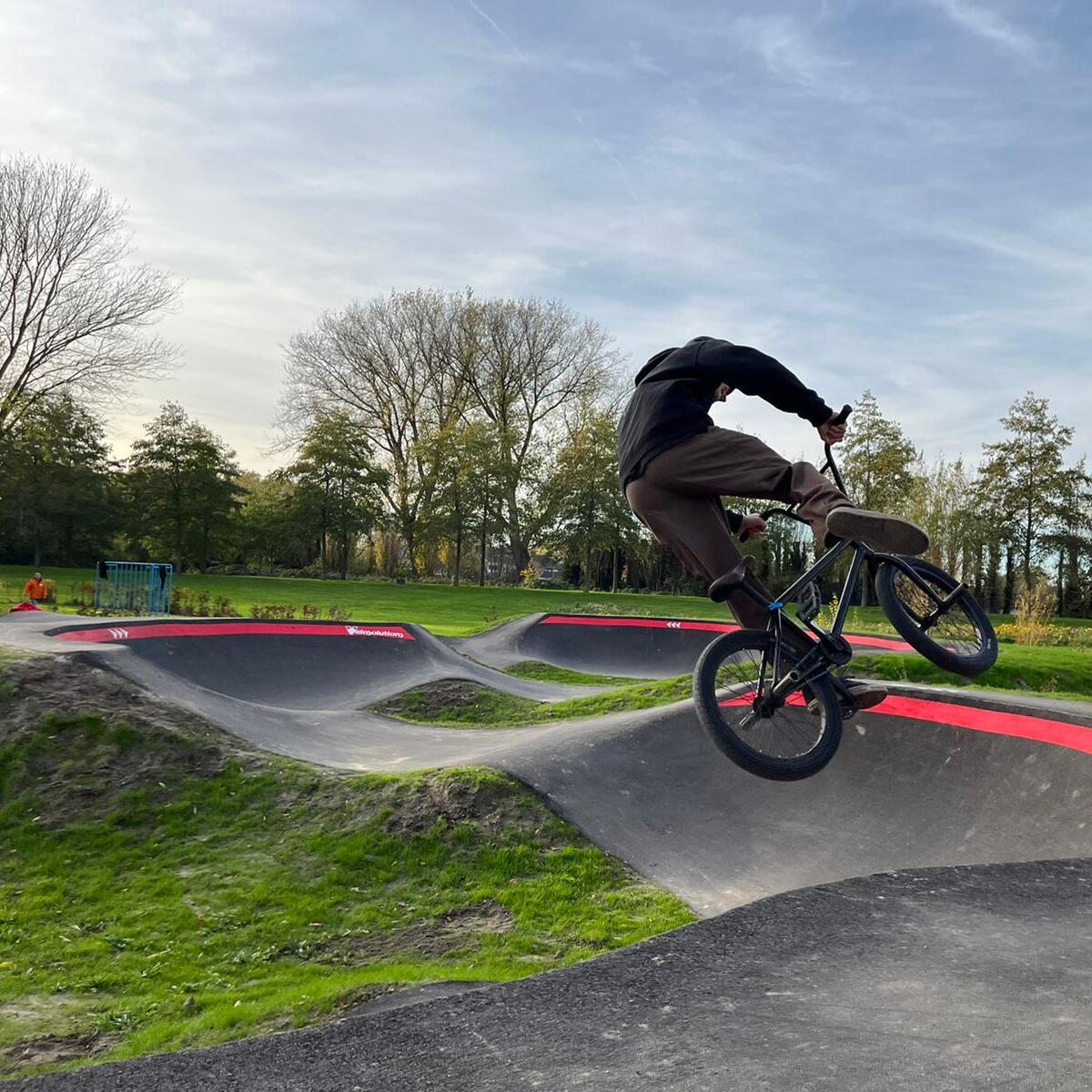 BMX'ers springt boven een kombocht uit op pumptrackbaan Sluiskil