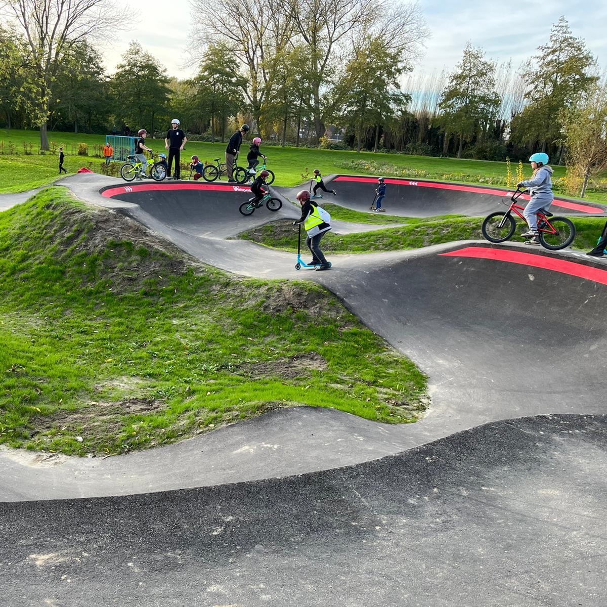 Jonge kinderen met stepjes spelen op de pumptrackbaan
