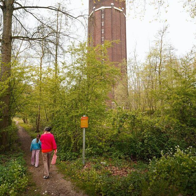 Twee mensen op weg via bospadje richting watertoren