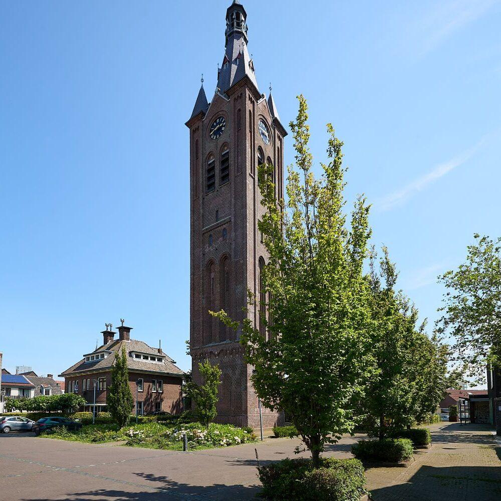 Willibrordustoren gefotografeerd van afstandje waardoor hoge piek zichtbaar is