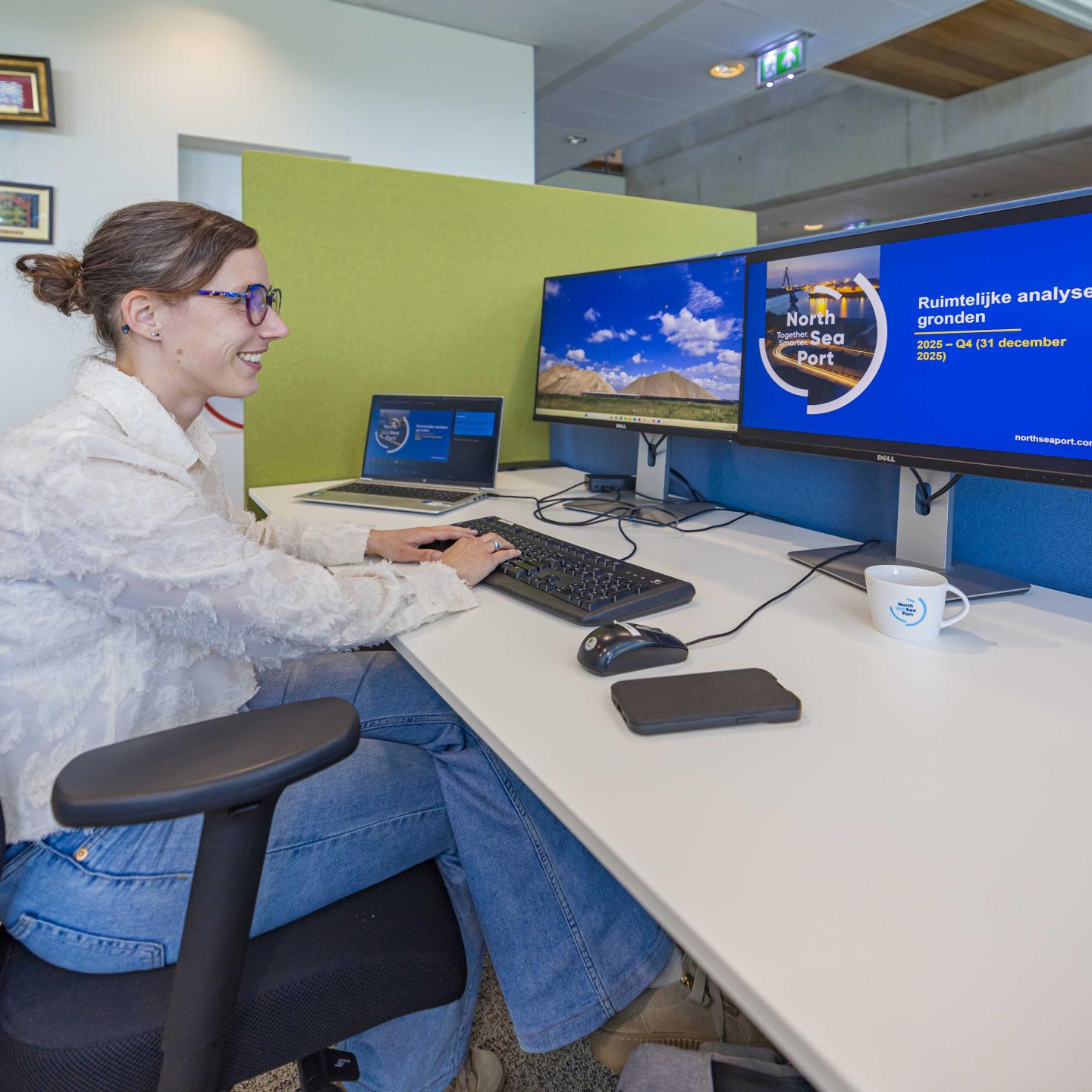 Lieke aan haar bureau achter een dubbel computerscherm