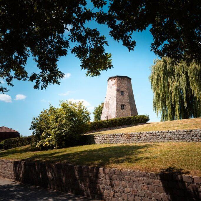 Molenberg met stenen muurtjes, bomen en de restanten van de oorspronkelijke molen
