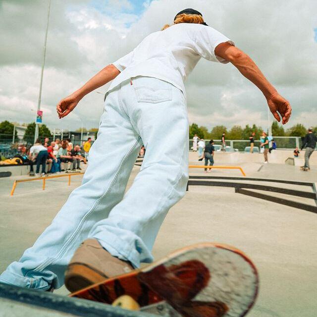 Skater van achteraf gefotografeerd terwijl hij bocht maakt op een helling