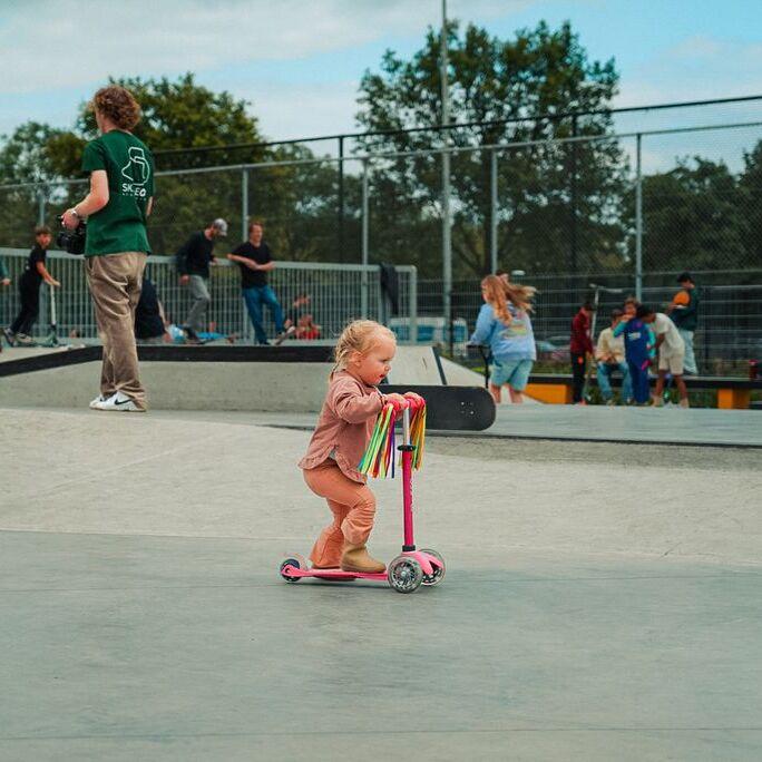 Piepjong meisje met haar stepje op de skatebaan in Terneuzen