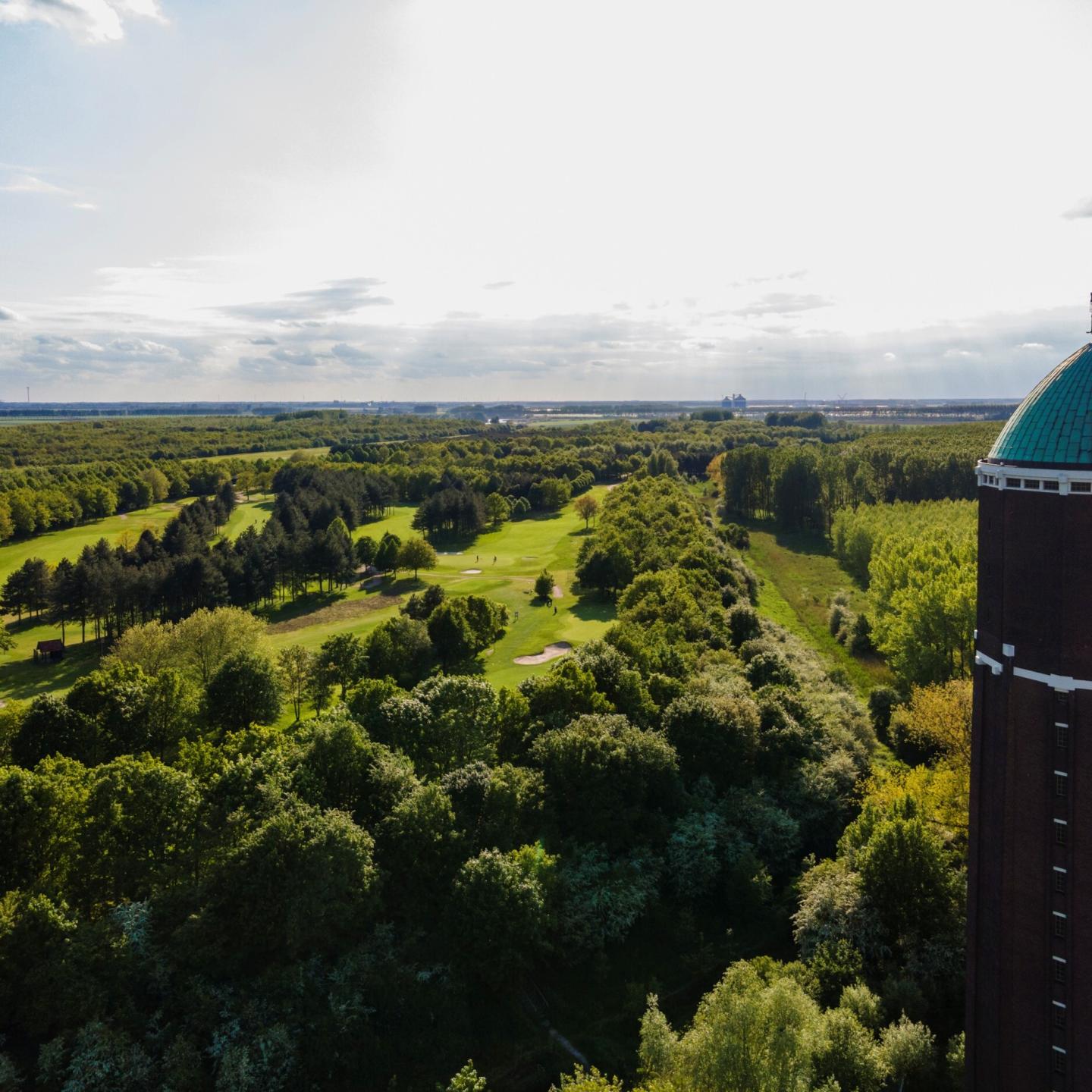 Golfbaan in Axel uit vogelvlucht gefotografeerd met rechts in beeld de watertoren van Axel