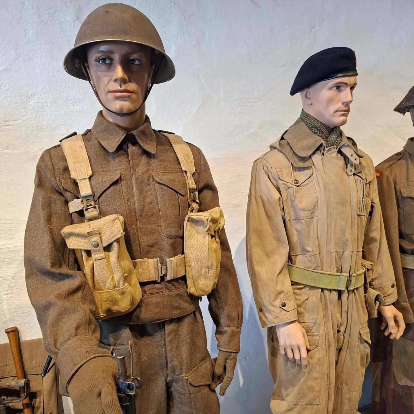 Twee paspoppen met oorlogstenue. De ene met helm, de andere met baret.