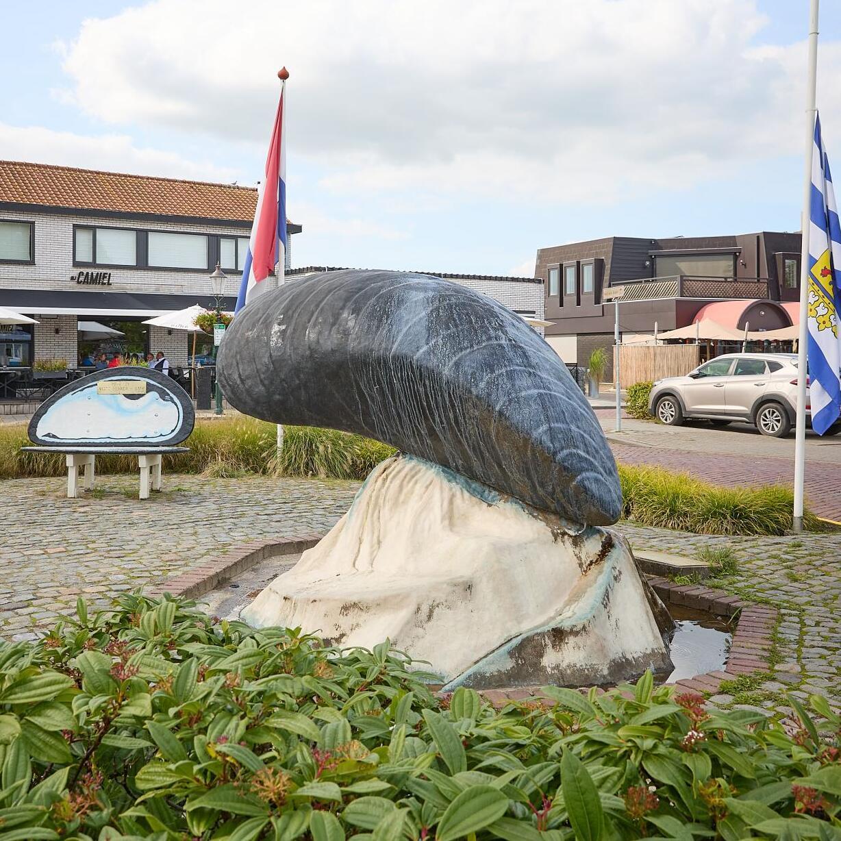 Groep mensen onder parasols die genieten van mosselfeest